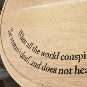 Words laser engraved into a mahogany desk top
